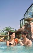 Zwei Gäste im Aussenpool mit einem Cocktail im EurothermenResort Bad Schallerbach Hotel Paradiso ****S